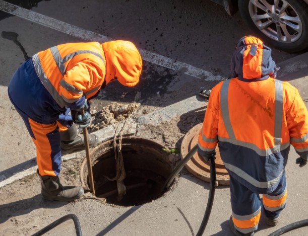 Operarios con equipo de protección trabajando en una arqueta de comunidad en Las Palmas
